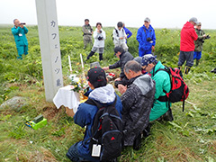 カフェノツ墓地（志発島）墓石を囲んで手を合わせる人々